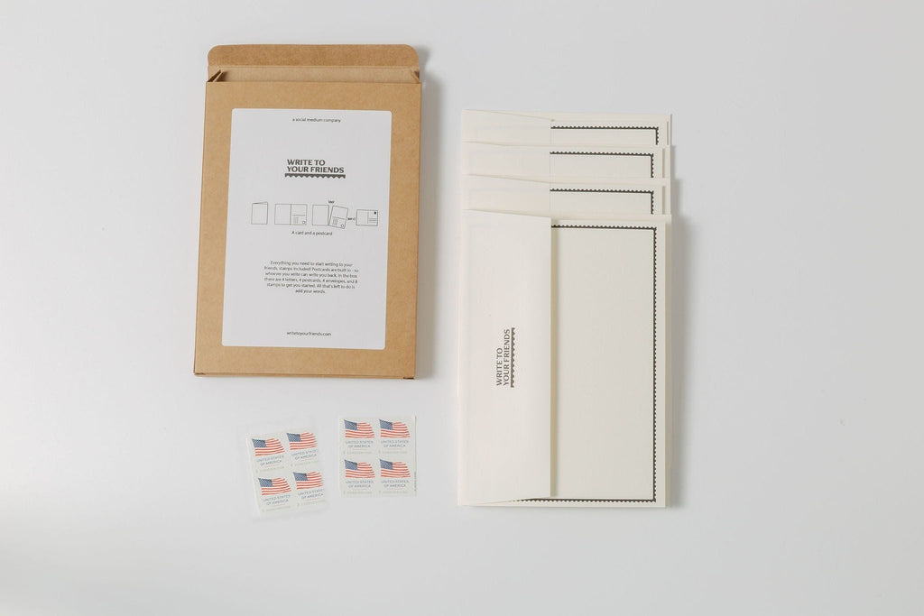 Everything in The Pack laid out: kraft box, four cards, four envelopes, and eight USPS Forever stamps