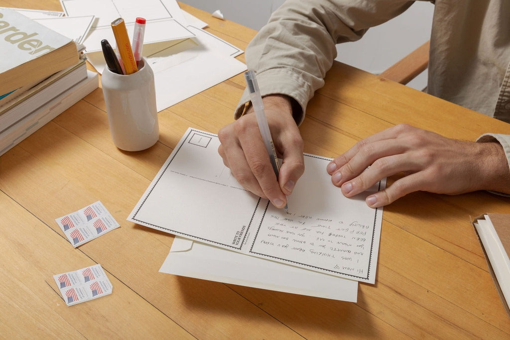 Writing a letter on a W2YF card at a wood desk, eight stamps on the table